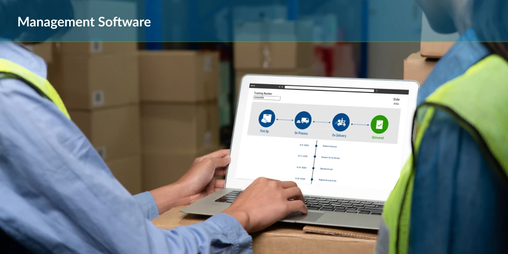 Worker using management software on a laptop in a warehouse setting