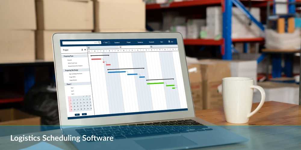 Laptop displaying Gantt chart with "Logistics Scheduling Software" caption, on a desk in a warehouse, next to a coffee mug.