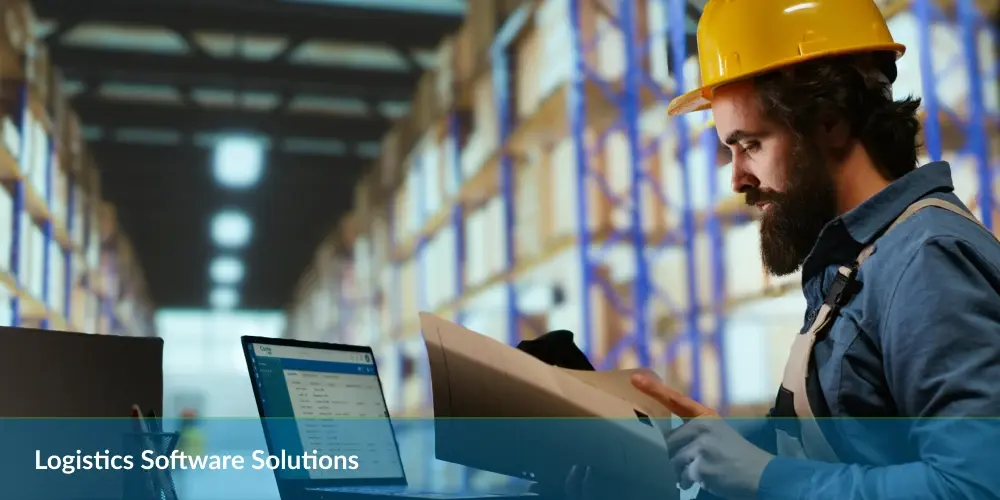 Worker in hard hat using a tablet in a warehouse with text "Logistics Software Solutions".