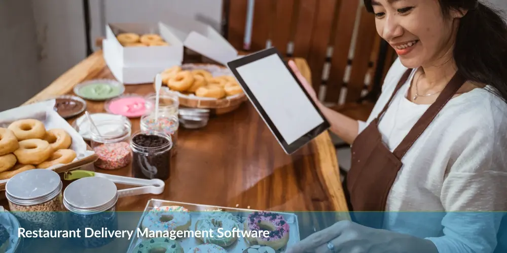 Person holding a tablet with donuts and toppings on the table, captioned 'Restaurant Delivery Management Software'.