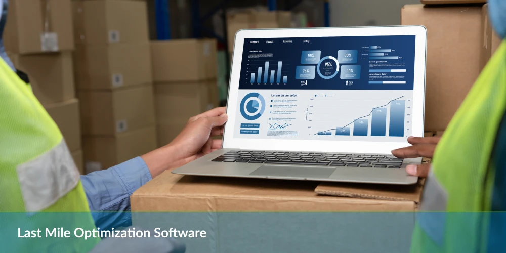 A laptop displaying last mile optimization software with performance graphs and metrics, placed on a stack of boxes in a warehouse.